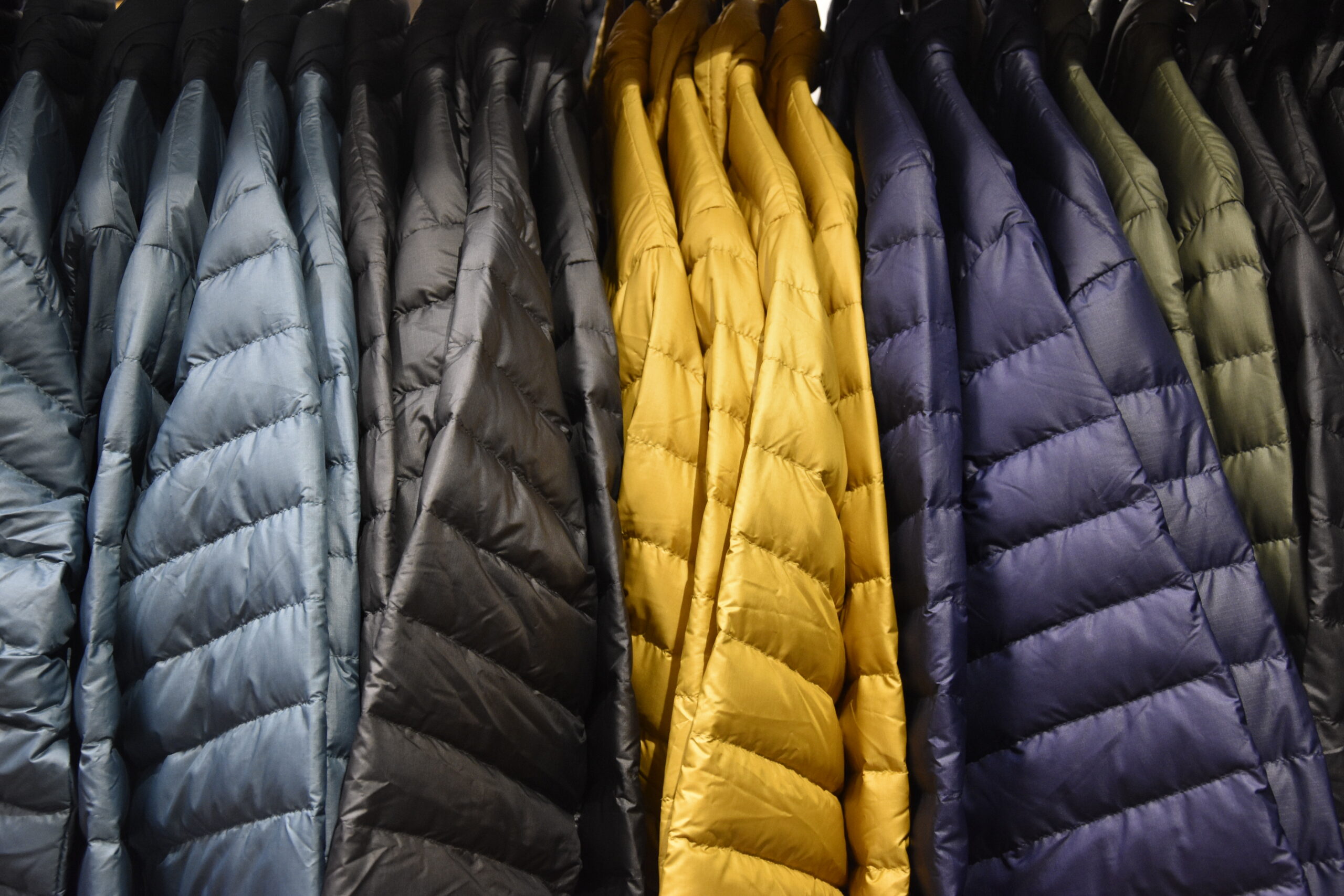 plusieurs doudounes colorés dans un dressing 