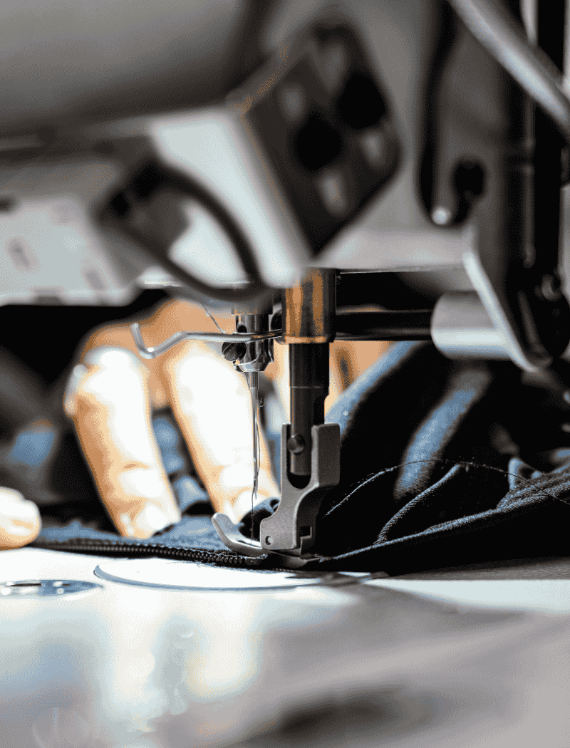 Réparation de la fermeture éclair d’une veste imperméable bleue dans l’atelier Goodloop.